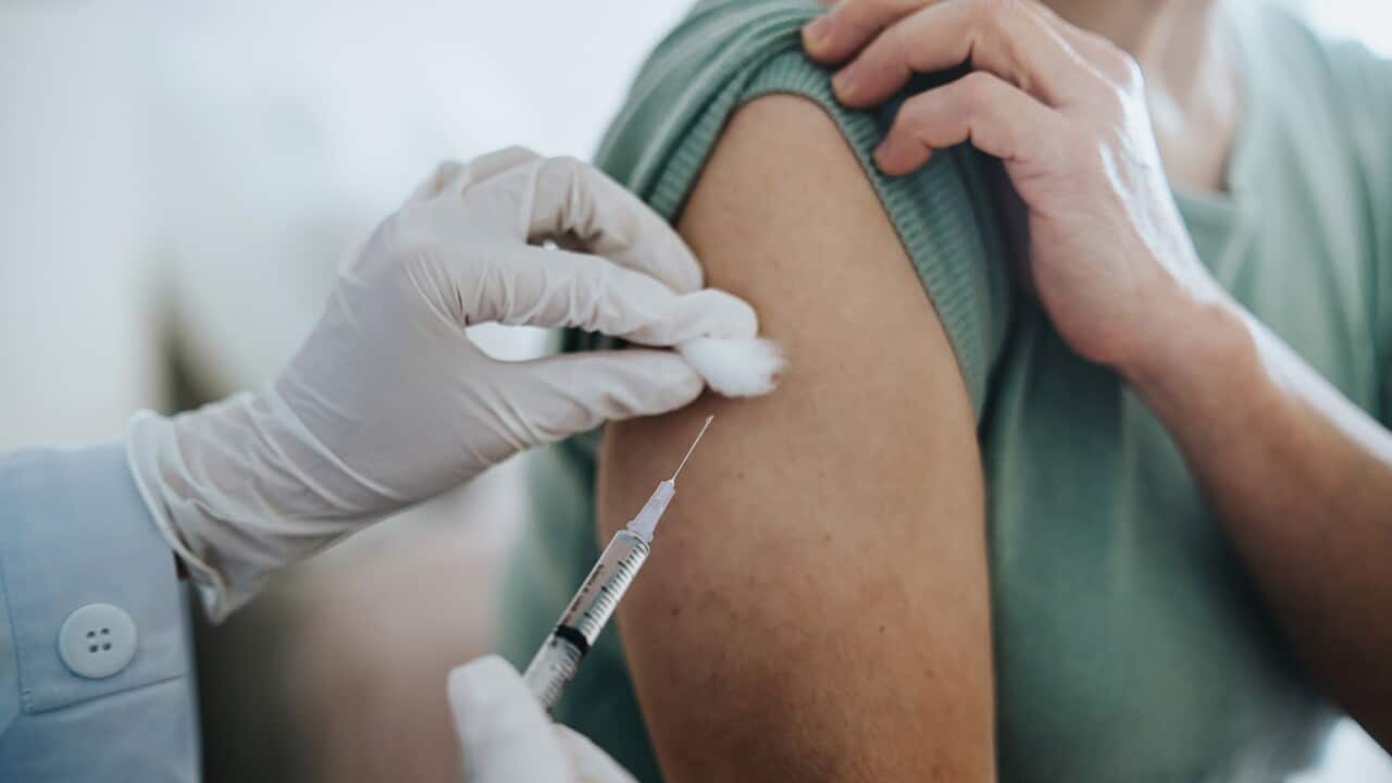 Close up of senior Asian woman getting Covid-19 vaccine in arm for Coronavirus immunization by a doctor at hospital. Elderly healthcare and illness prevention concept