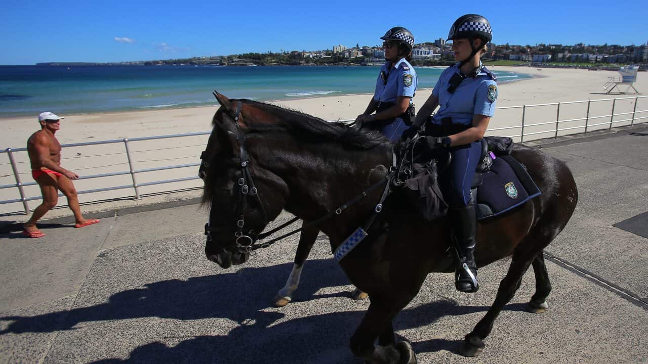 Police on horses enforce social distancing regulations at Bondi Beach.