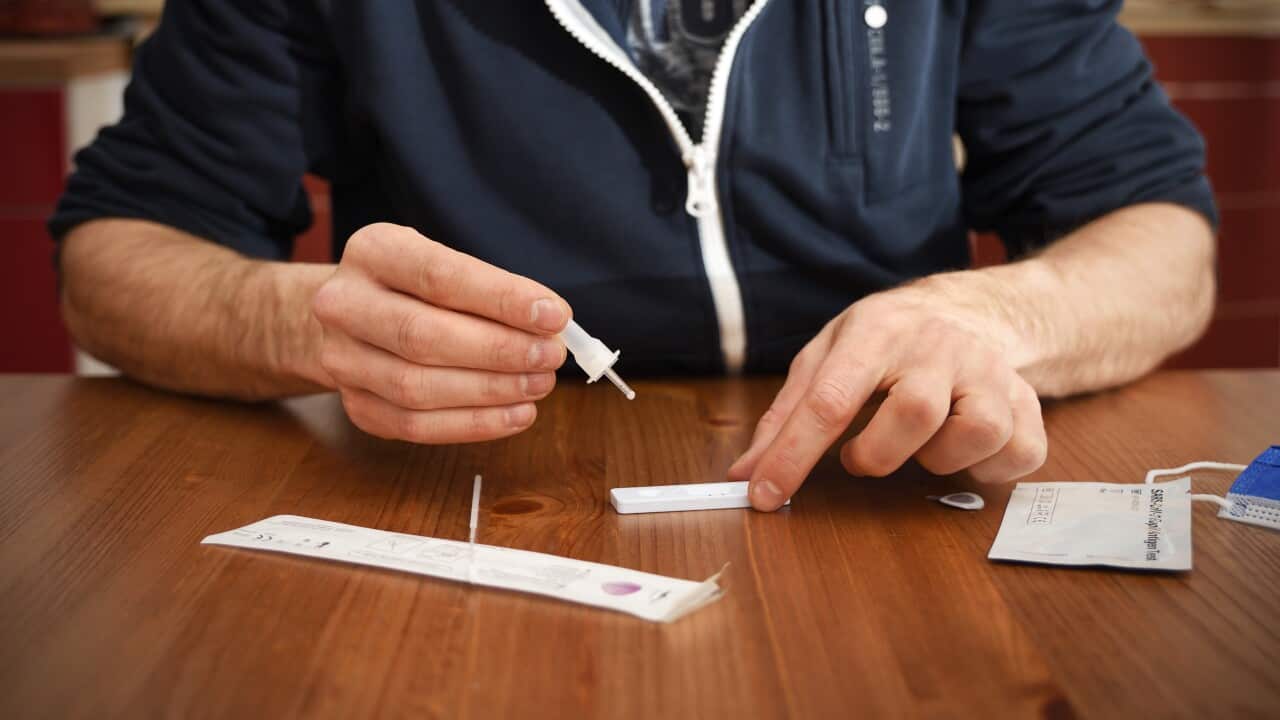 man in a jaket makes a rapid test for antibodies to coronavirus covid 19 at home. He opened a rapid test kit, and dropes a drop of analysis solution onto the rapid antigen test