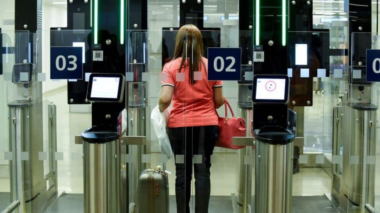A passenger uses an automated passport control channel.