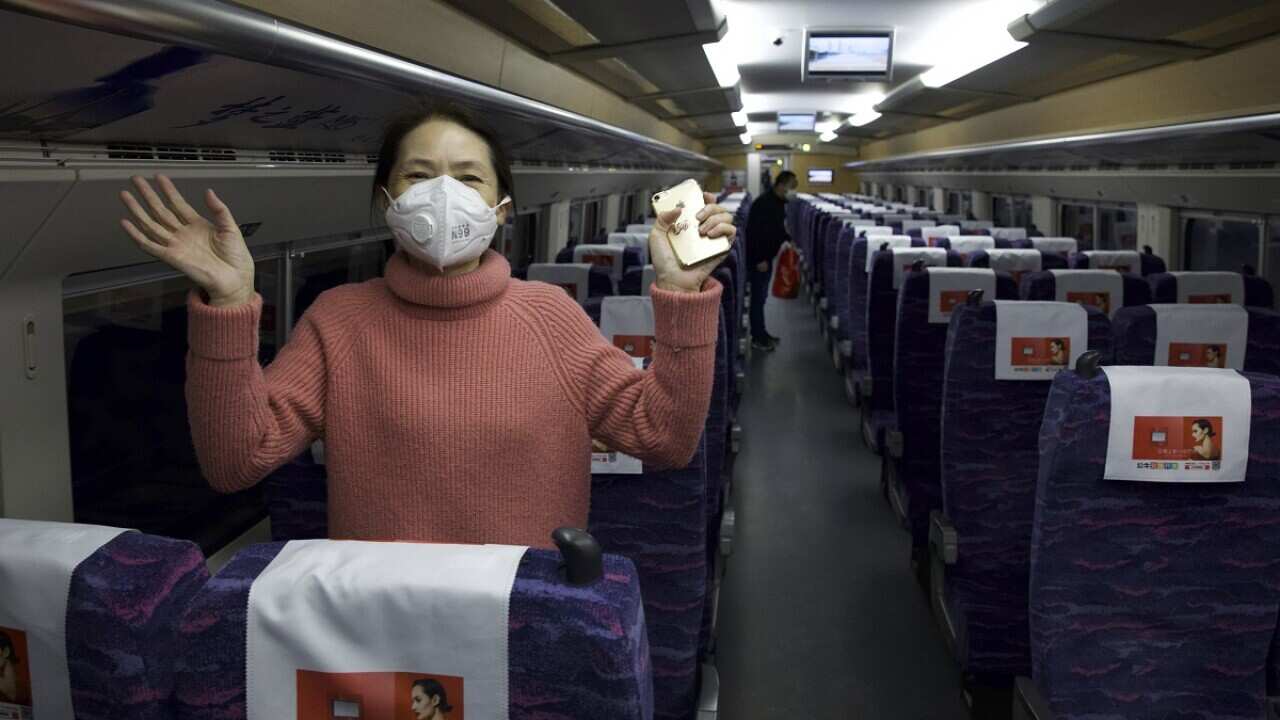 A woman celebrates the end of lockdown on the first train from Wuhan April 8, 2020.