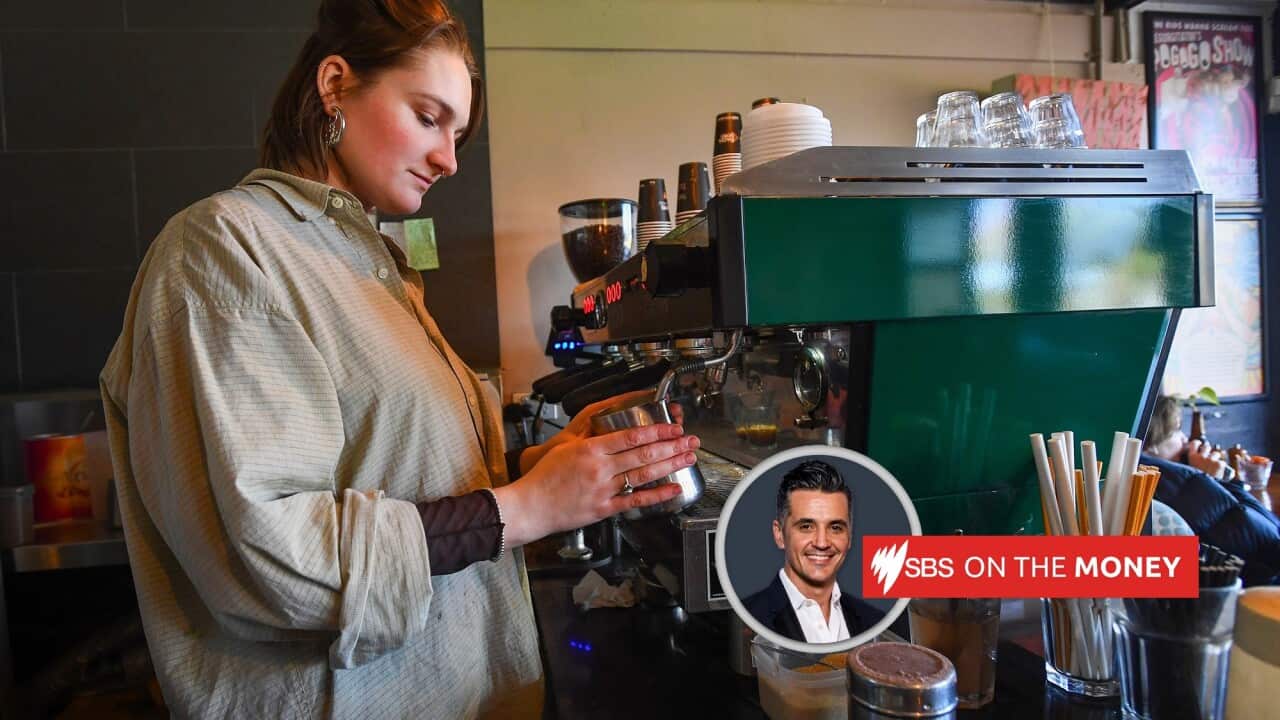 A barista operates a coffee machine.