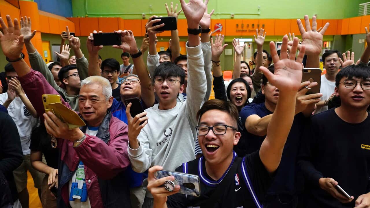 Supporters of pro-democracy candidate Angus Wong celebrate after he won in district council elections in Hong Kong,