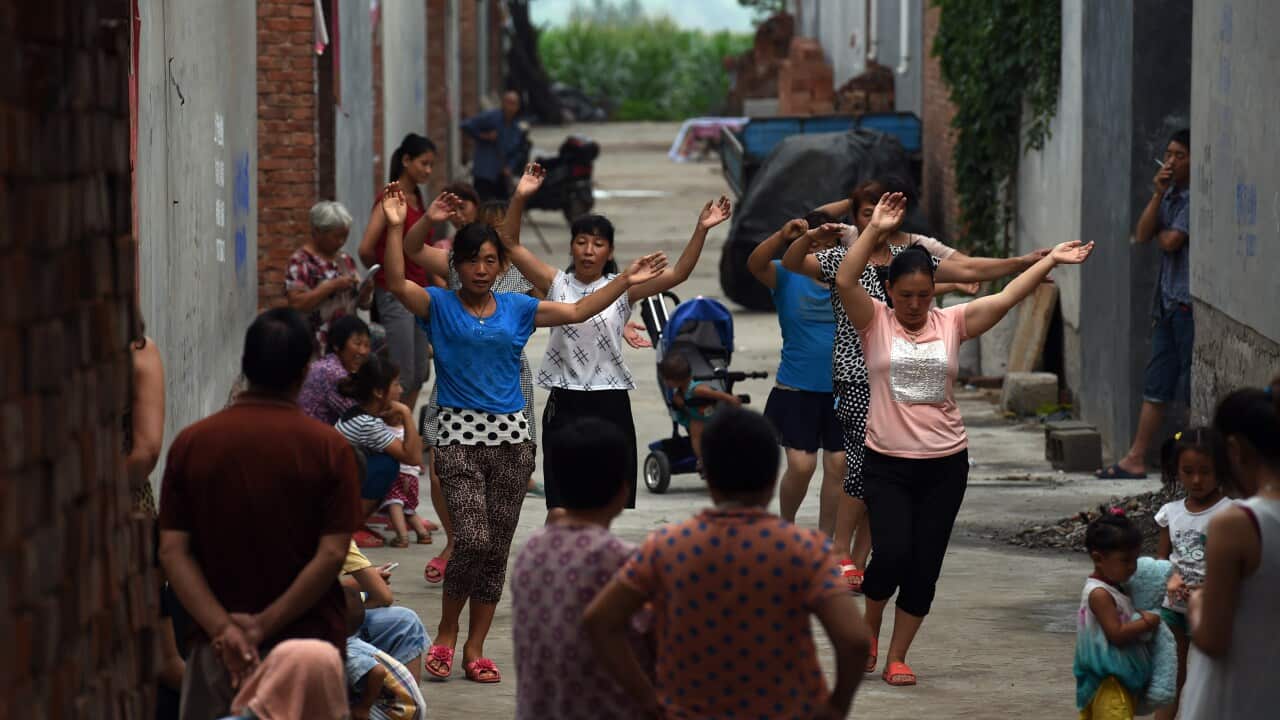 A group of women take part in an early morning dance session, as villagers look on, in Weijian village, in China's Henan province. Group dancing and exercise are popular activities in villages across the country.