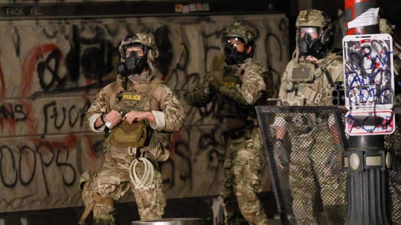 A Federal agent prepares a CS canister after protesters dismantle a fence at Portland, Oregon’s Federal Courthouse on 19 July, 2020.