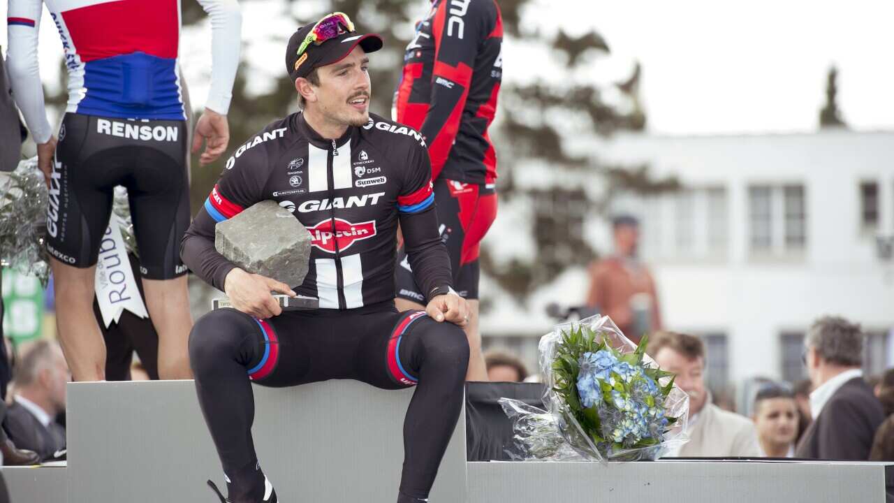 John Degenkolb team Giant - Alpecin wins Paris Roubaix 2015 and walks onto the podium to collect his trophy..