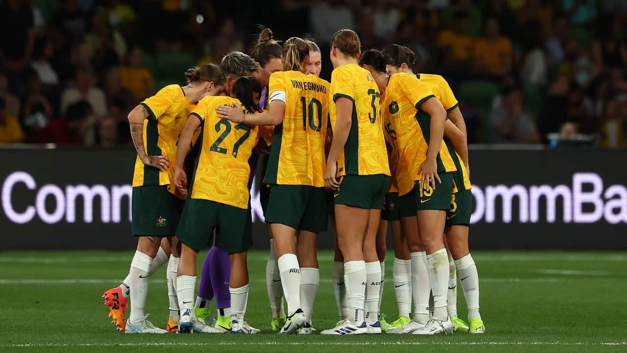 Female football players huddling on the field