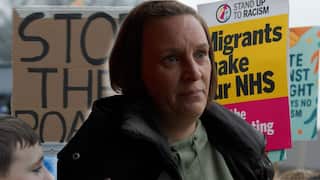 On the left is a protest poster reading 'stop the boats'. On the right is a protest poster reading 'migrants make our NHS. Stop the scapegoating'. Superimposed on the front is a woman with short hair and a neutral facial expression.