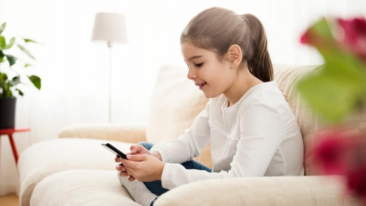Little girl having fun with smart phone at home