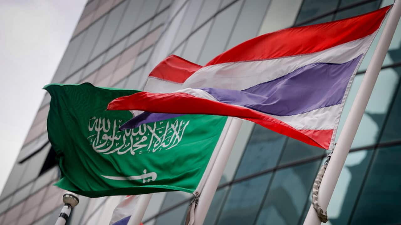 A Saudi Arabian national flag flies next to a Thai national flag outside the Saudi embassy in Bangkok