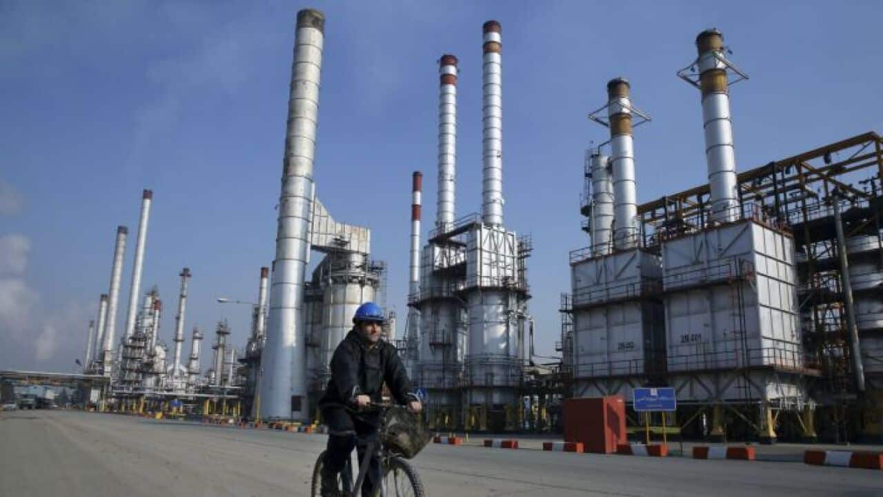 An Iranian oil worker rides his bicycle at the Tehran oil refinery, south of the capital Tehran, Iran.