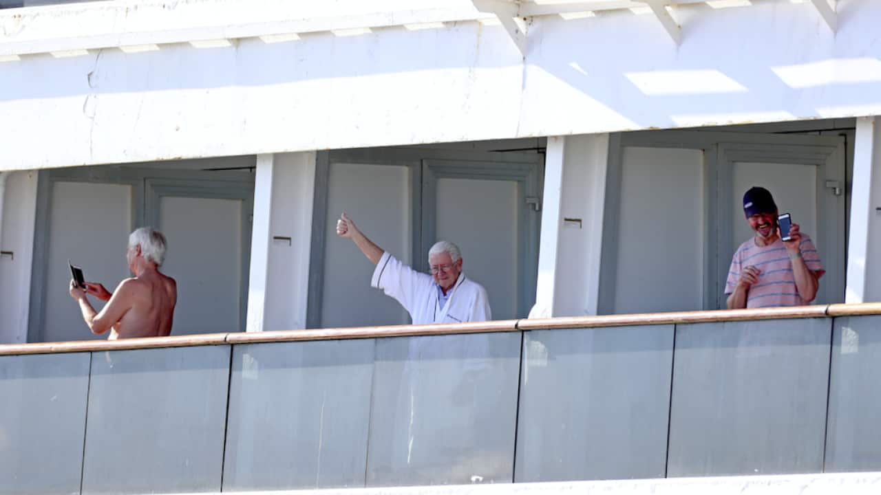 Passengers aboard Holland America's Zaandam cruise ship as it heads into Port Everglades in Fort Lauderdale.