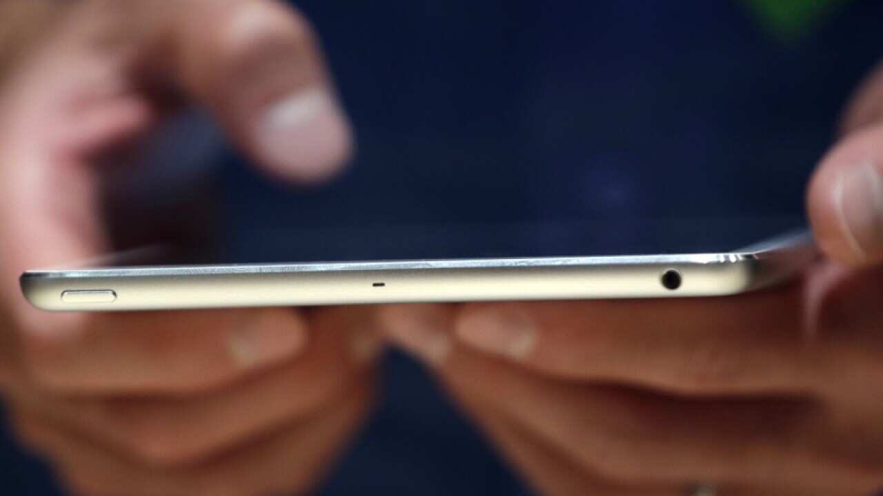 A person holding Apple's iPad Mini