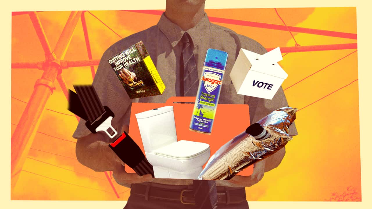 A cartoon man wearing a shirt and tie holds an orange briefcase with objects including a seat belt, toilet, goon bag, Aerogard, ballot box and cigarettes spilling out. A Hills Hoist is in the background.