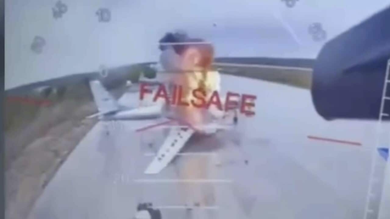 A low resolution photo of a plane on fire on a runway.