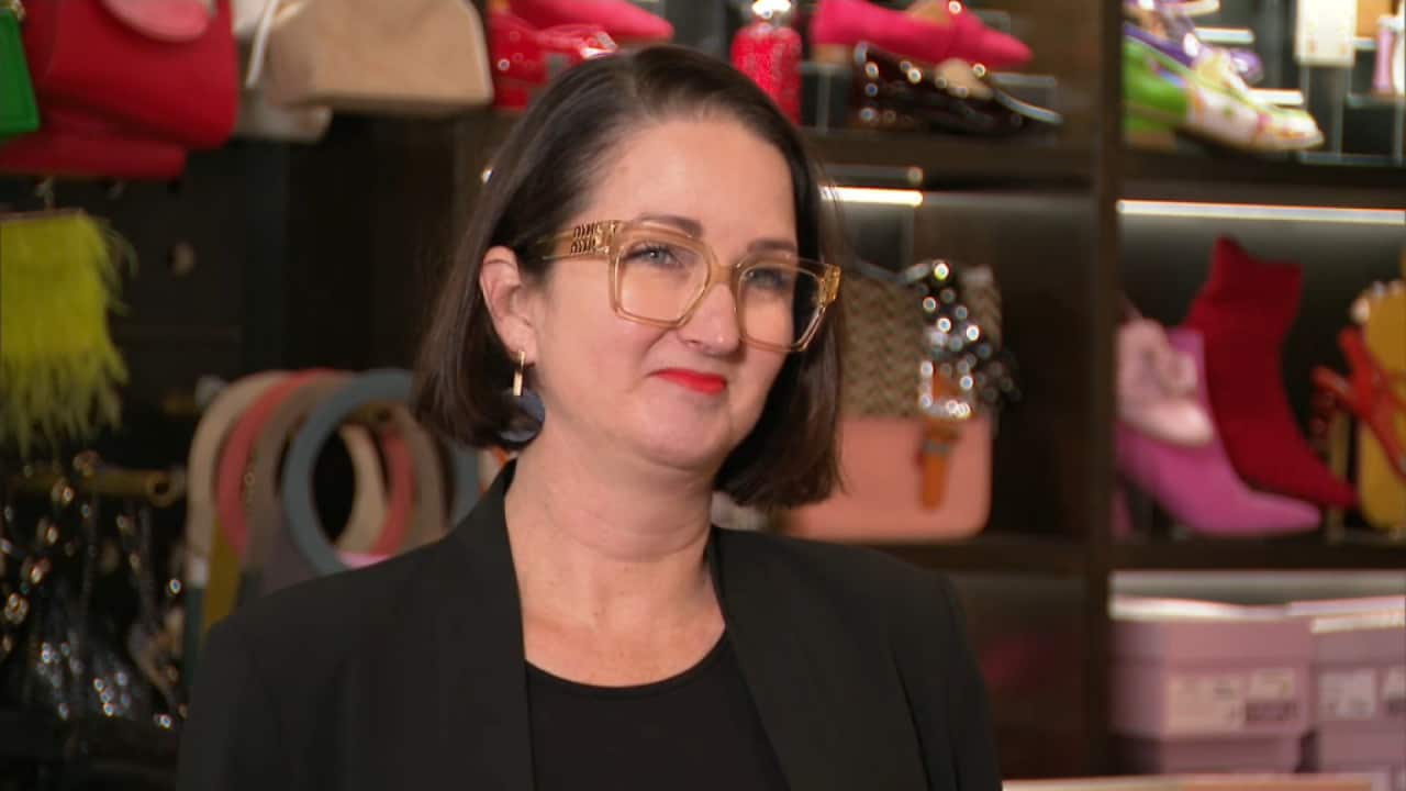 Woman wearing clear-framed glasses and red lipstick.