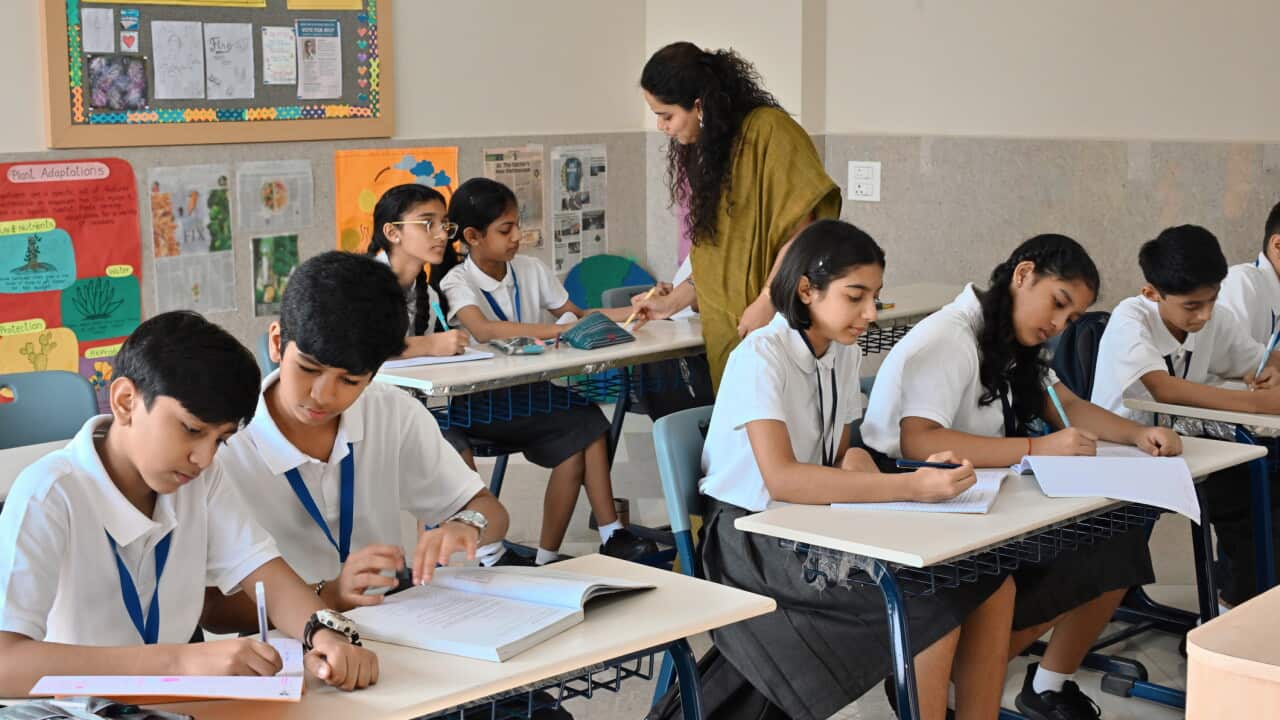 Indian school teacher helping students during classroom activity