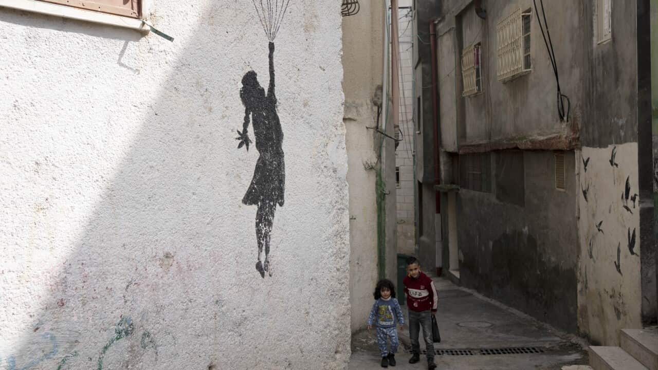 Palestinian children walk in an alley of the Aida Refugee Camp, near the health clinic and school run by the the United Nations Relief and Works Agency for Palestinian Refugees in the Near East (UNRWA) in the West Bank city of Bethlehem, Tuesday, Feb. 20, 2024.