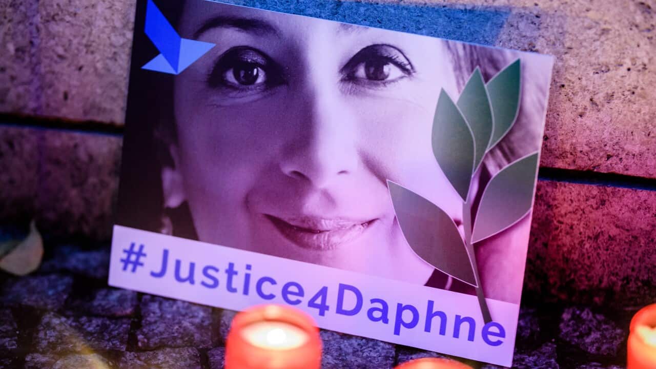 'Justice four Daphne' is written on a cardboard showing a photo of Daphne Caruana Galizia.