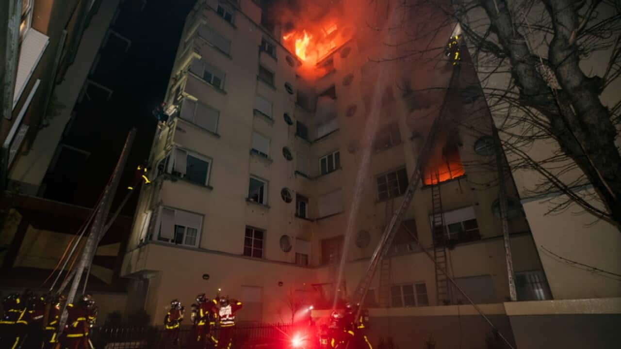 Firefighters attend a fire at an apartment in western Paris, France