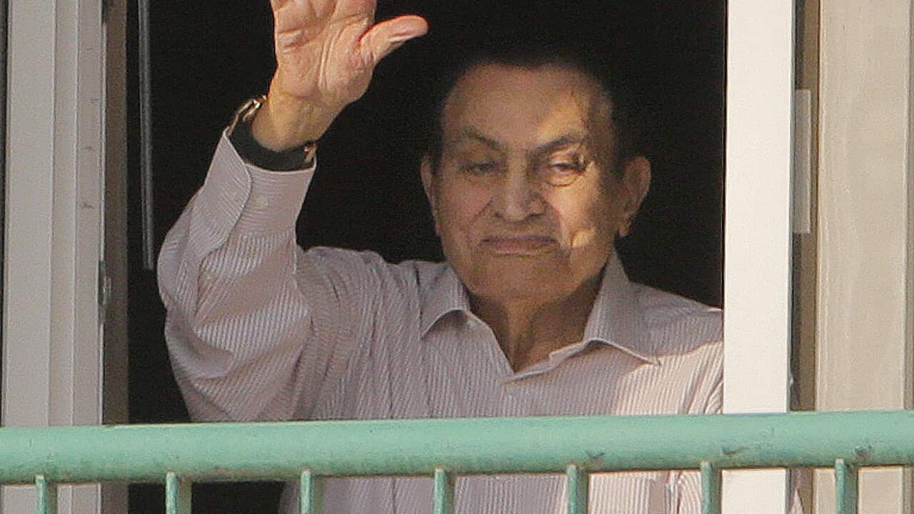Ousted former Egyptian President Hosni Mubarak waves to his supporters from his room at the Maadi Military Hospital Thursday.