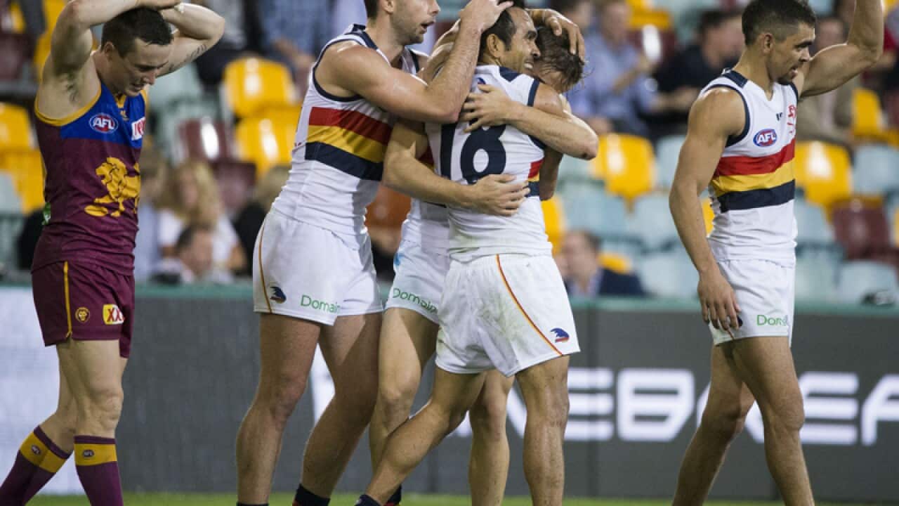 Jordan Gallucci of the Crows (2R) celebrates after kicking a goal