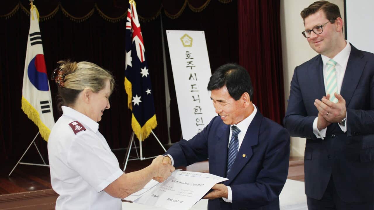Three cheques amounting to $50,000 are presented by Mr Bob Yoon, the President of the Korean Society of Sydney to the Salvation Army representative.
