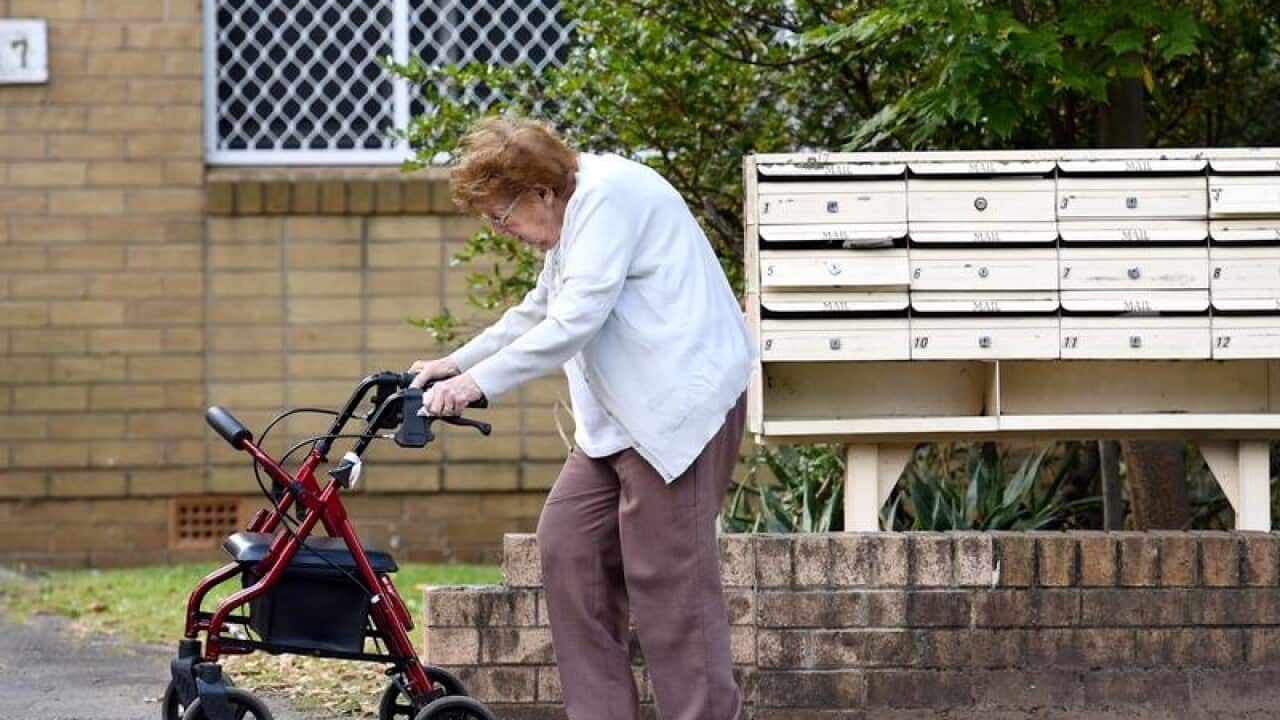 An elderly woman uses a mobility walker in Sydney