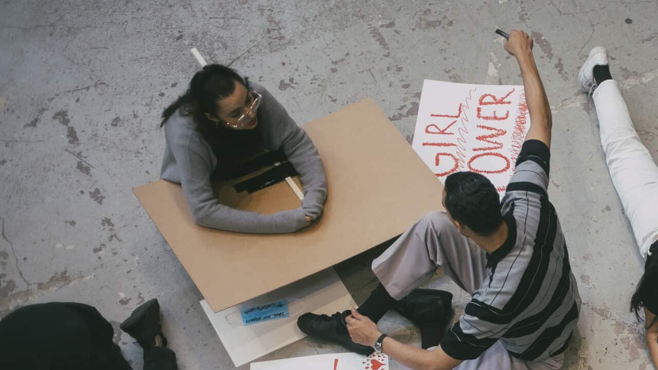 High angle view of female and male protestor preparing signboards for human rights