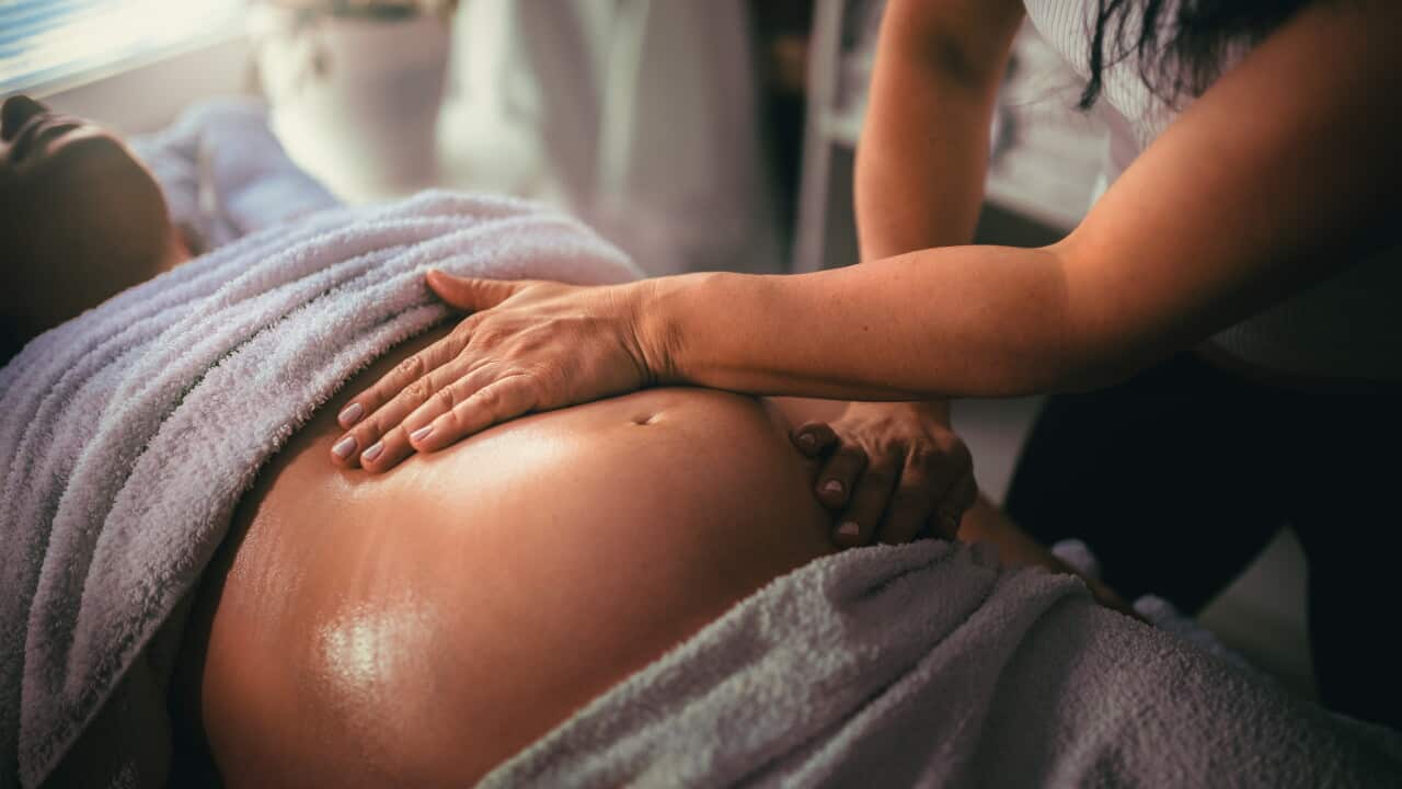 Pregnant woman having massage in spa relax