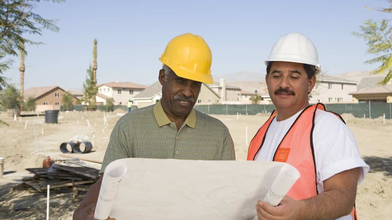 Surveyor and contraction worker at construction site