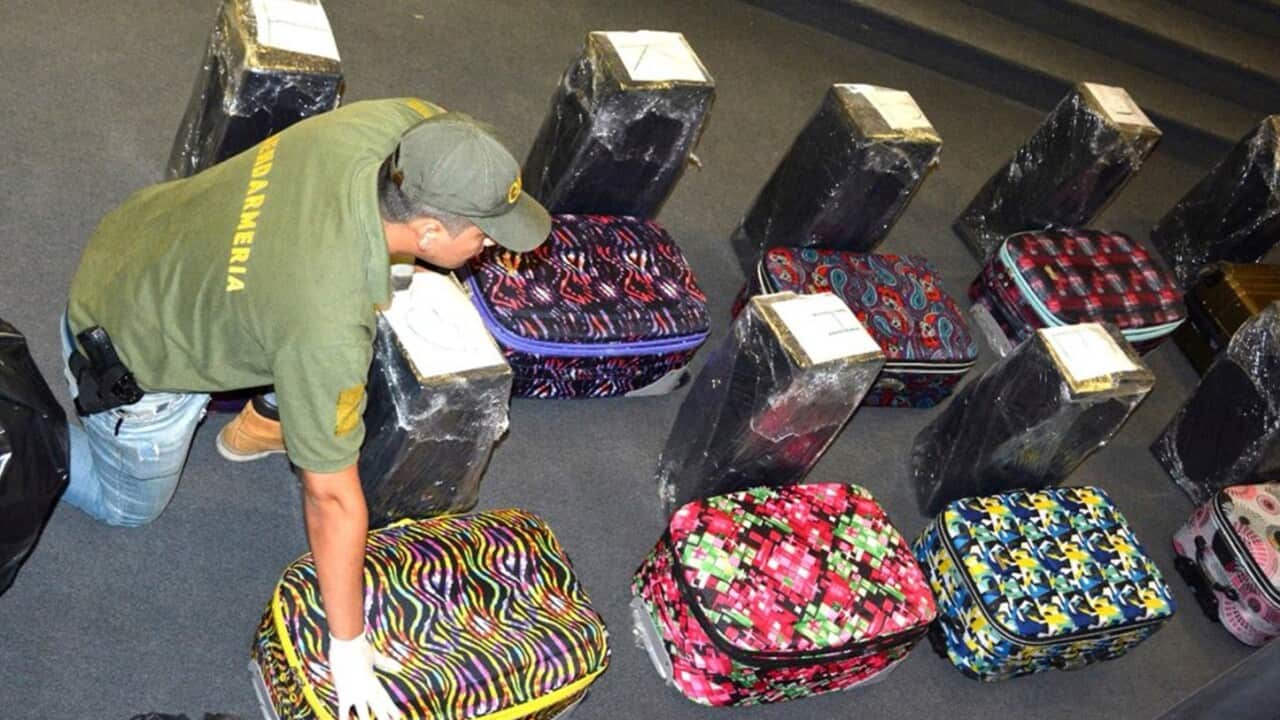 Image released on Feb. 22, 2018 of a police officer guards suitcases that carried cocaine, that were found in an annex building 
