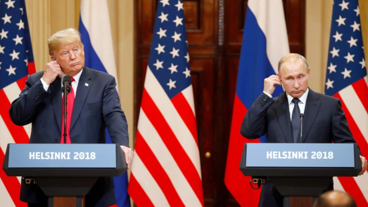 US President Donald J. Trump and Russian President Vladimir Putin adjust their earpiece plugs during a joint press conference following their summit talks.