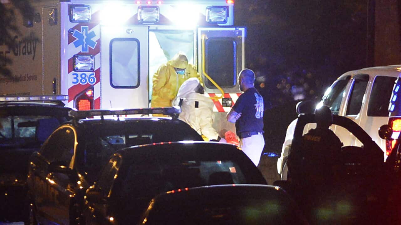 An ambulance carrying a healthcare worker arrives at a hospital