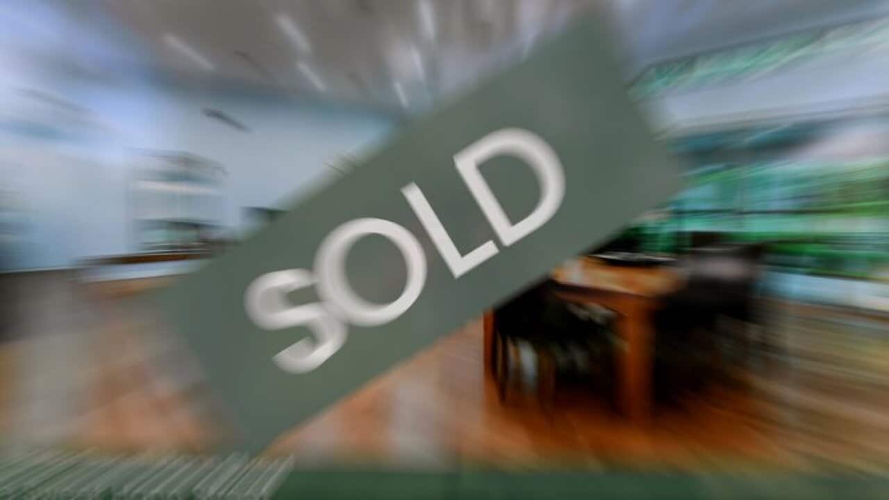 A real estate advertising board with a Sold sign.