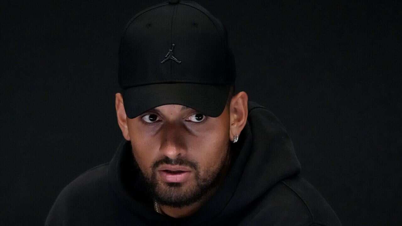 Australia's Nick Kyrgios reacts as he announces his withdrawal from the Australian Open with a knee injury at a press conference in Melbourne