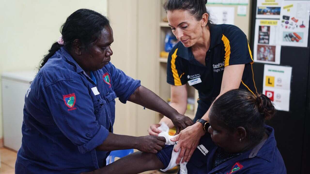 Care Flight nurse Jayne Sheppard teaches Thamarrurr Rangers how to tourniquet