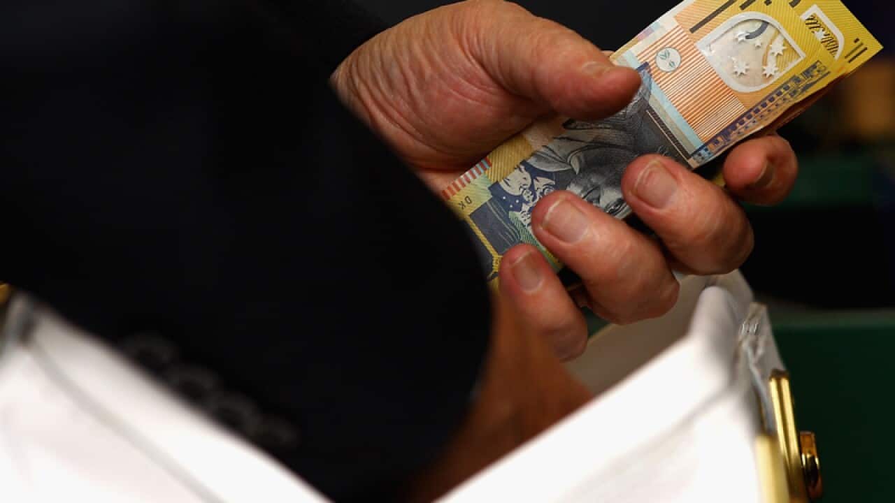 A bookie counts his money at the $6.2m race (Getty)