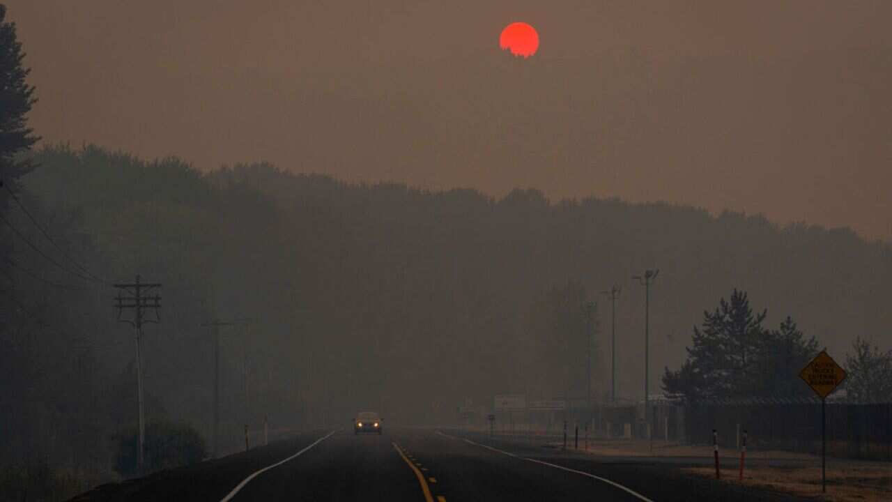 Tinted orange by wildfire smoke from Oregon and southern Washington, the sun sets behind a hill on September 9.