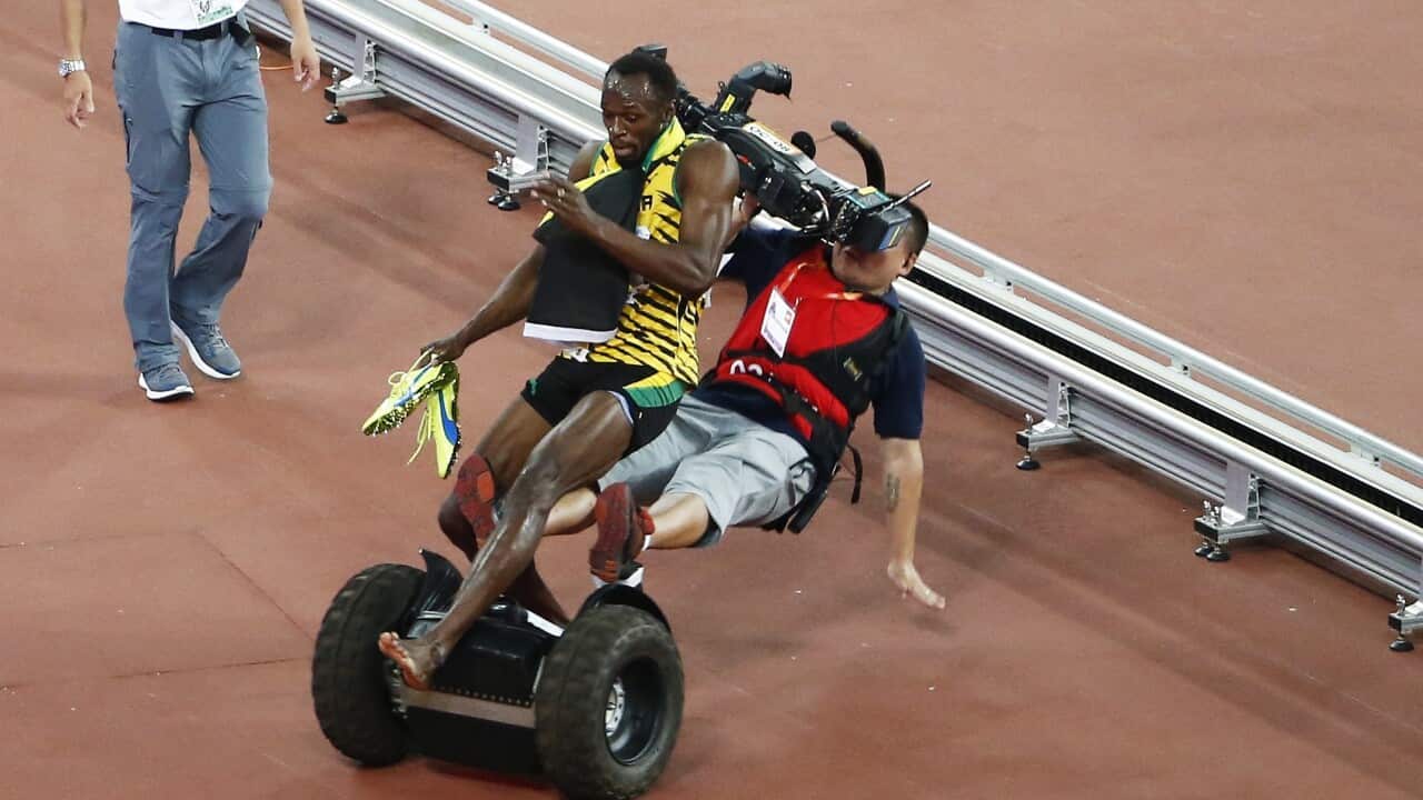 A Tv cameraman drives into Usain Bolt