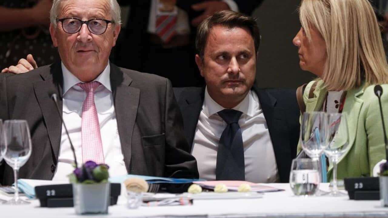 Luxembourg Prime Minister Xavier Bettel speaks to Jean-Claude Juncker