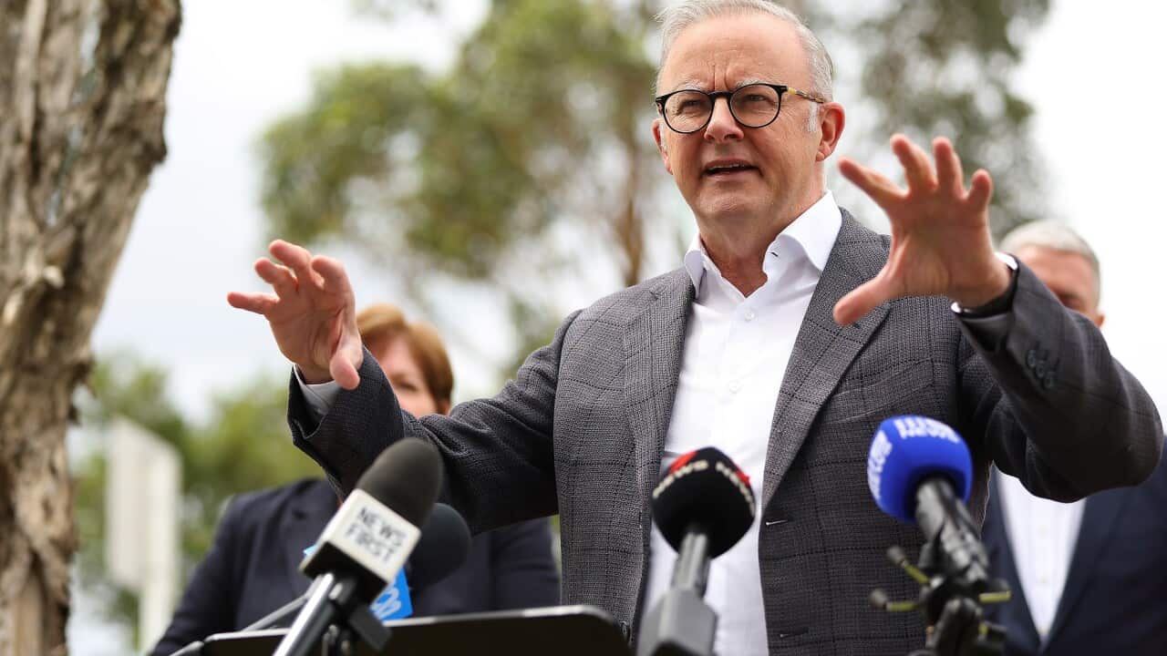 The Prime Minister Anthony Albanese standing in front of microphones.