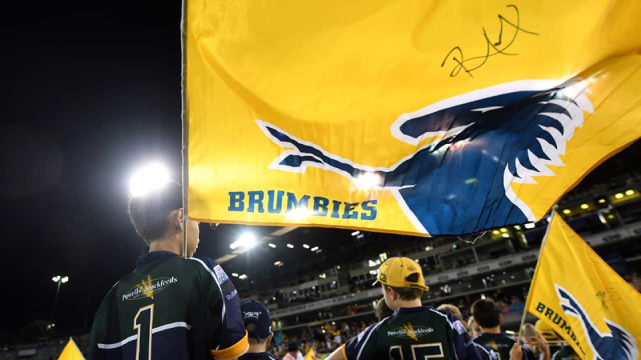 Boys hold up Brumbies flags