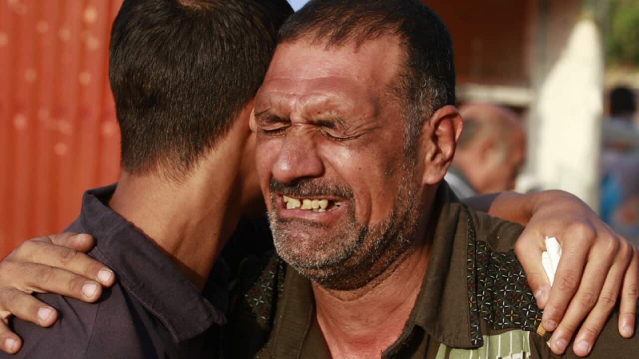 Relatives grieve for a victim of a suicide bomb attack in Baghdad