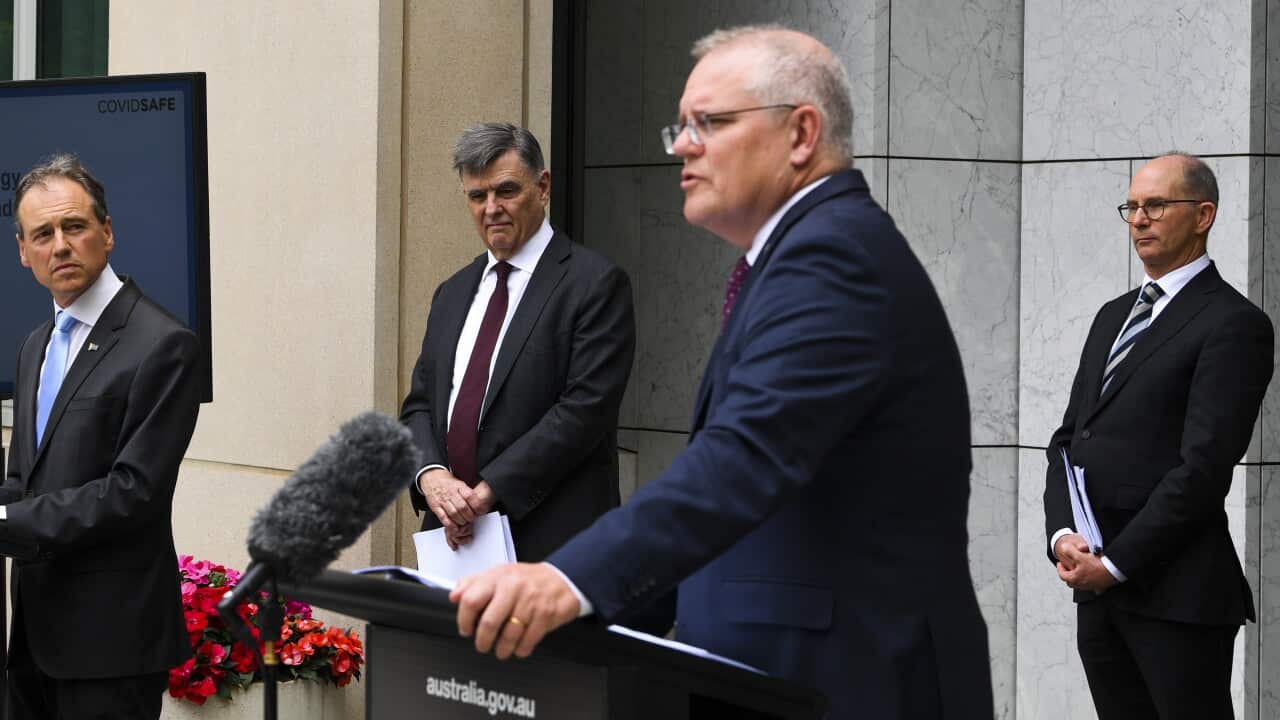 Greg Hunt (left), Brendan Murphy (centre) and Paul Kelly listen to Scott Morrison during a press conference.
