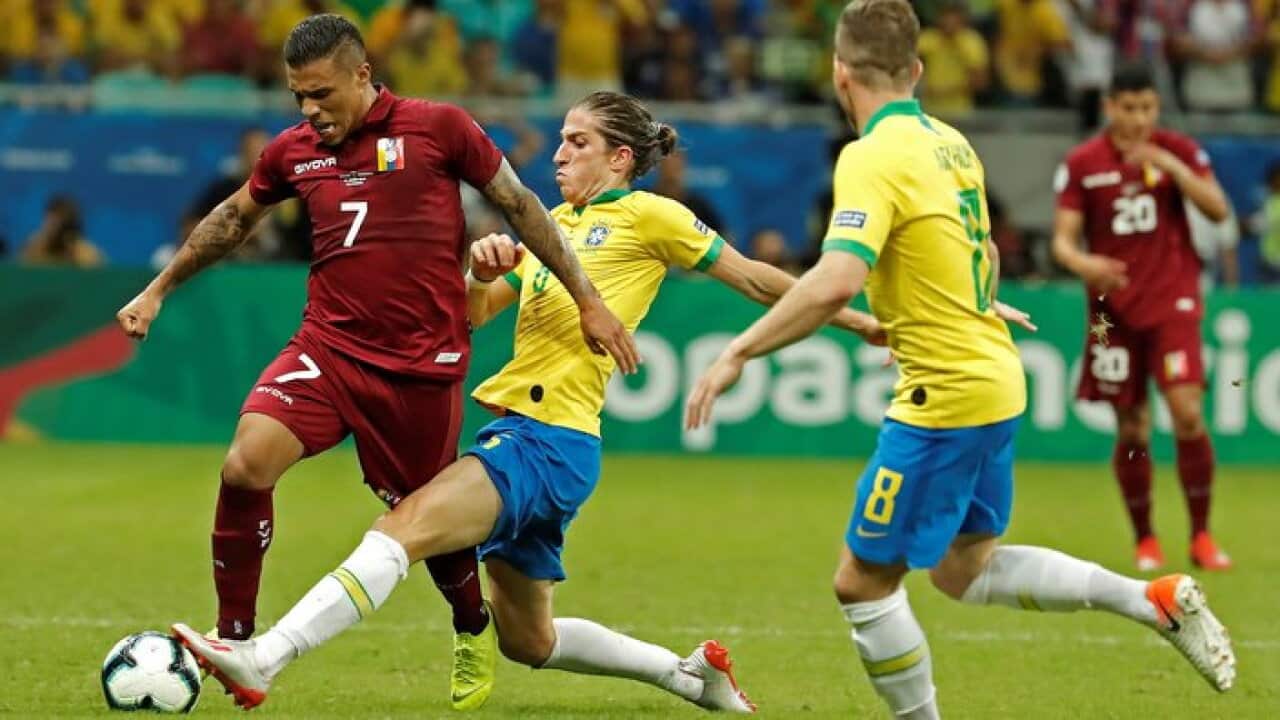 Venezuelan Darwin Machis (L) vies for the ball with Brazilians Filipe Luis (C) and Arthur (R)