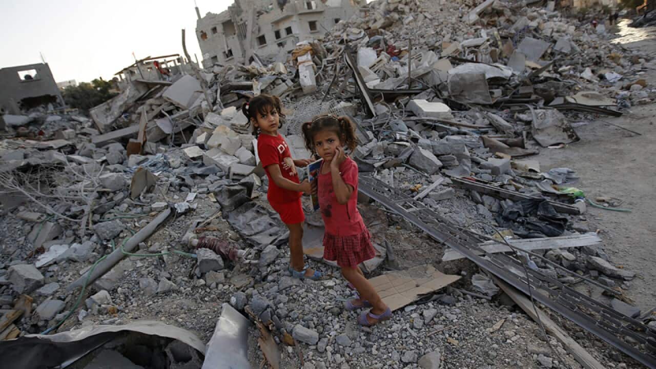 Children amidst the rubble of their home.