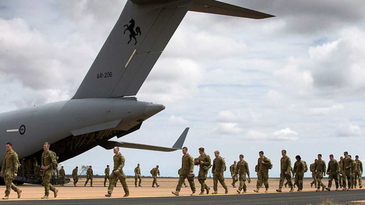 Australian Army soldiers from 5th Battalion, Royal Australian Regiment, exit a No 36 Squadron C-17A Globemaster III aircraft.