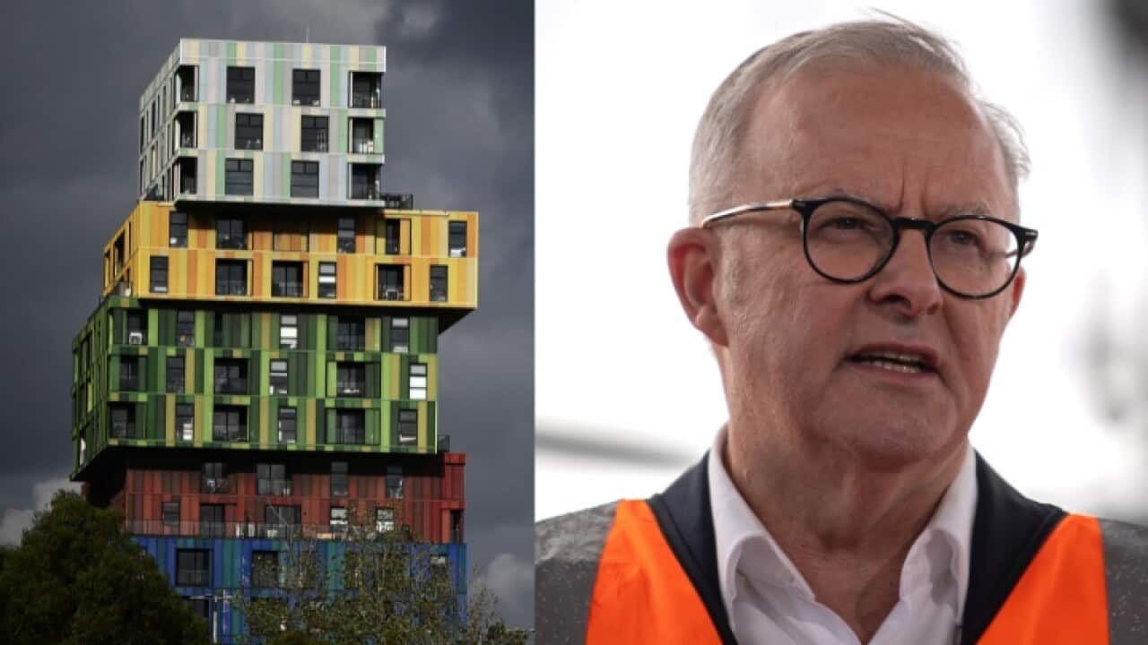 A man in high vis and an apartment building