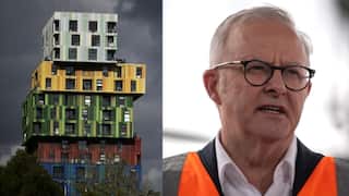 A man in high vis and an apartment building